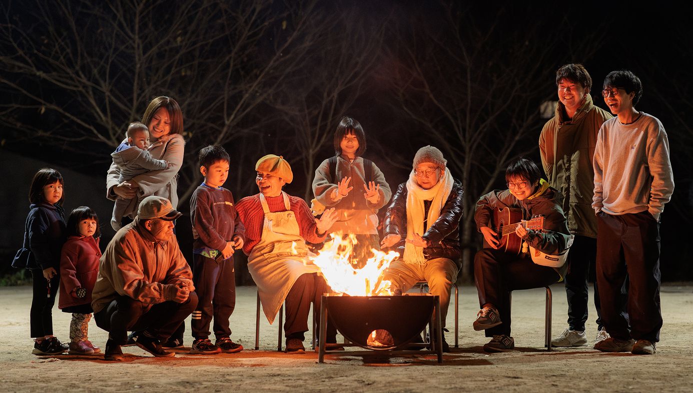 子供からお年寄りまでが焚き火にあたりごきげんに過ごしている