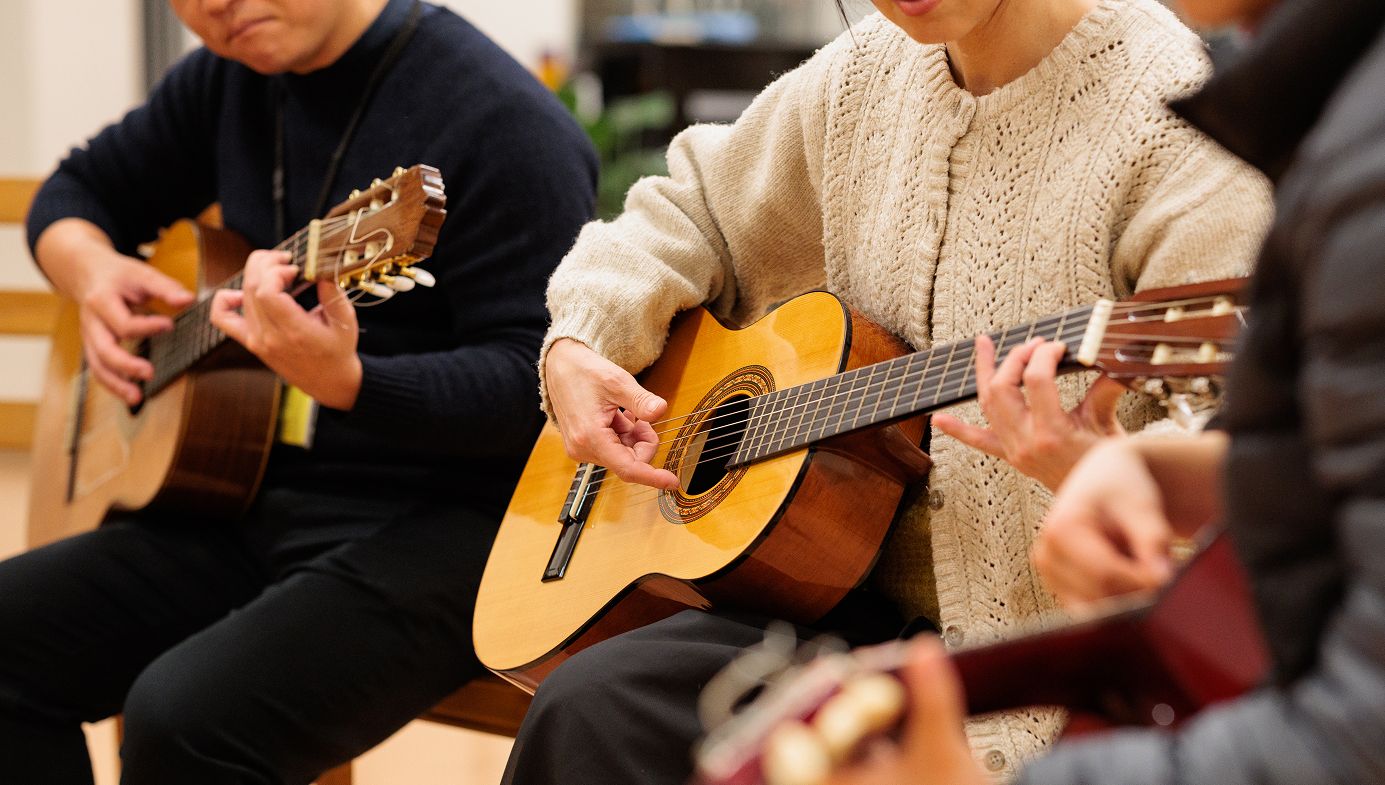 ギターを弾いてる3人