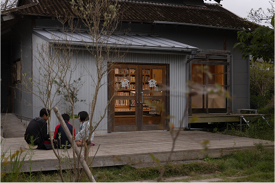 白い外壁の中にたくさんの本が並んでいるの見えるWAJIMA館