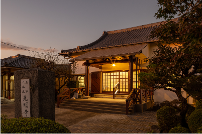 夕焼けの中オレンジの明かりが灯る光明寺館