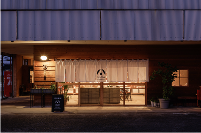 大きな白いのれんがかかったコメーキングスペース館